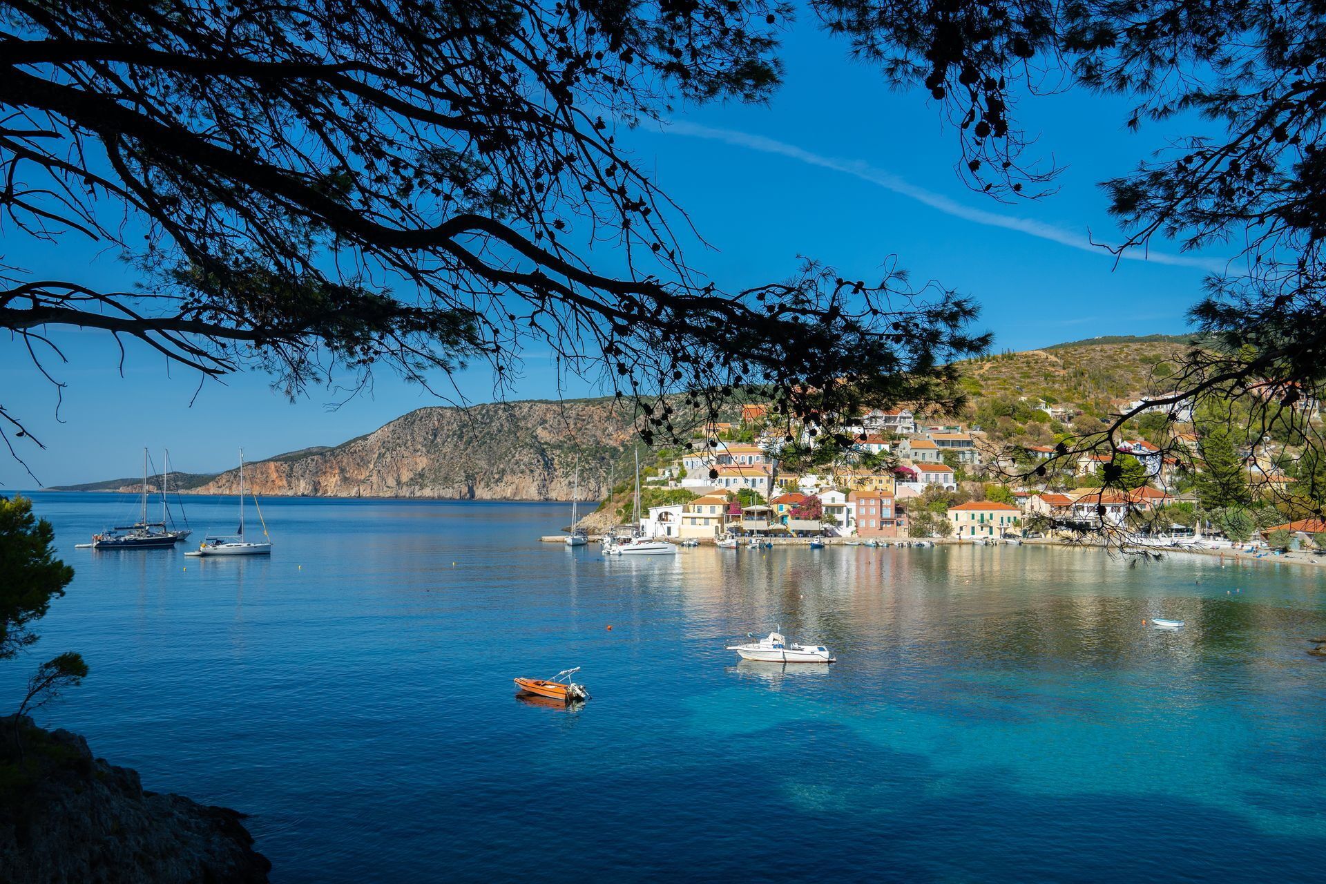 Scenic bay with stunning sea water, pine trees. Assos village