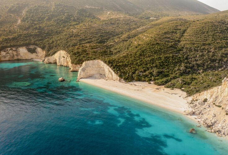 Fteri beach lined by massive limestone